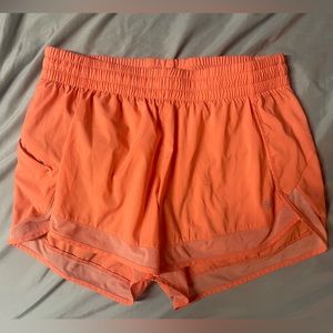 Athleta sized medium coral orange shorts with side zipper pocket